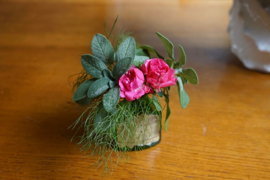 A tiny old aspirin bottle filled with cuttings from the yard